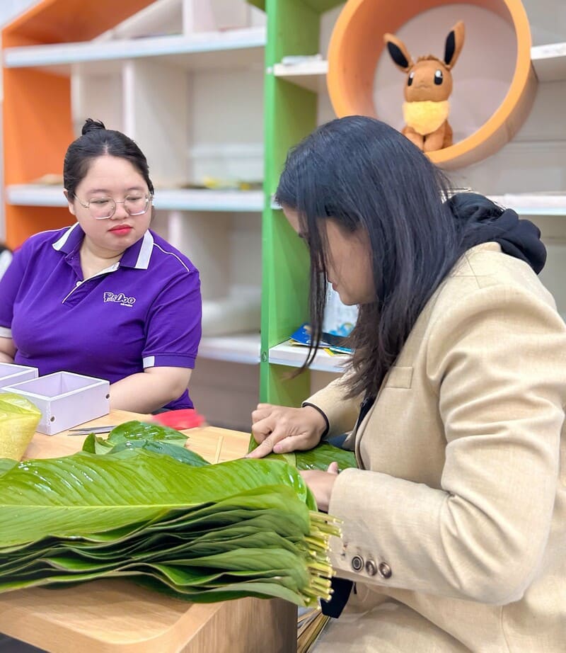 Các cô chăm chú học cách gói bánh chưng