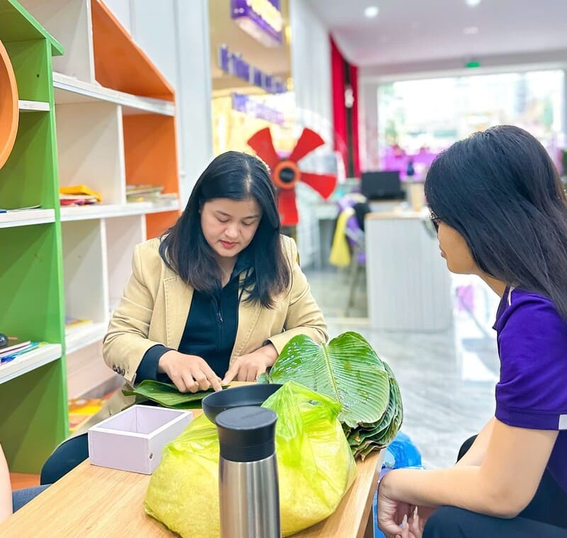 Các cô hướng dẫn nhau cách xếp lá gói bánh chưng